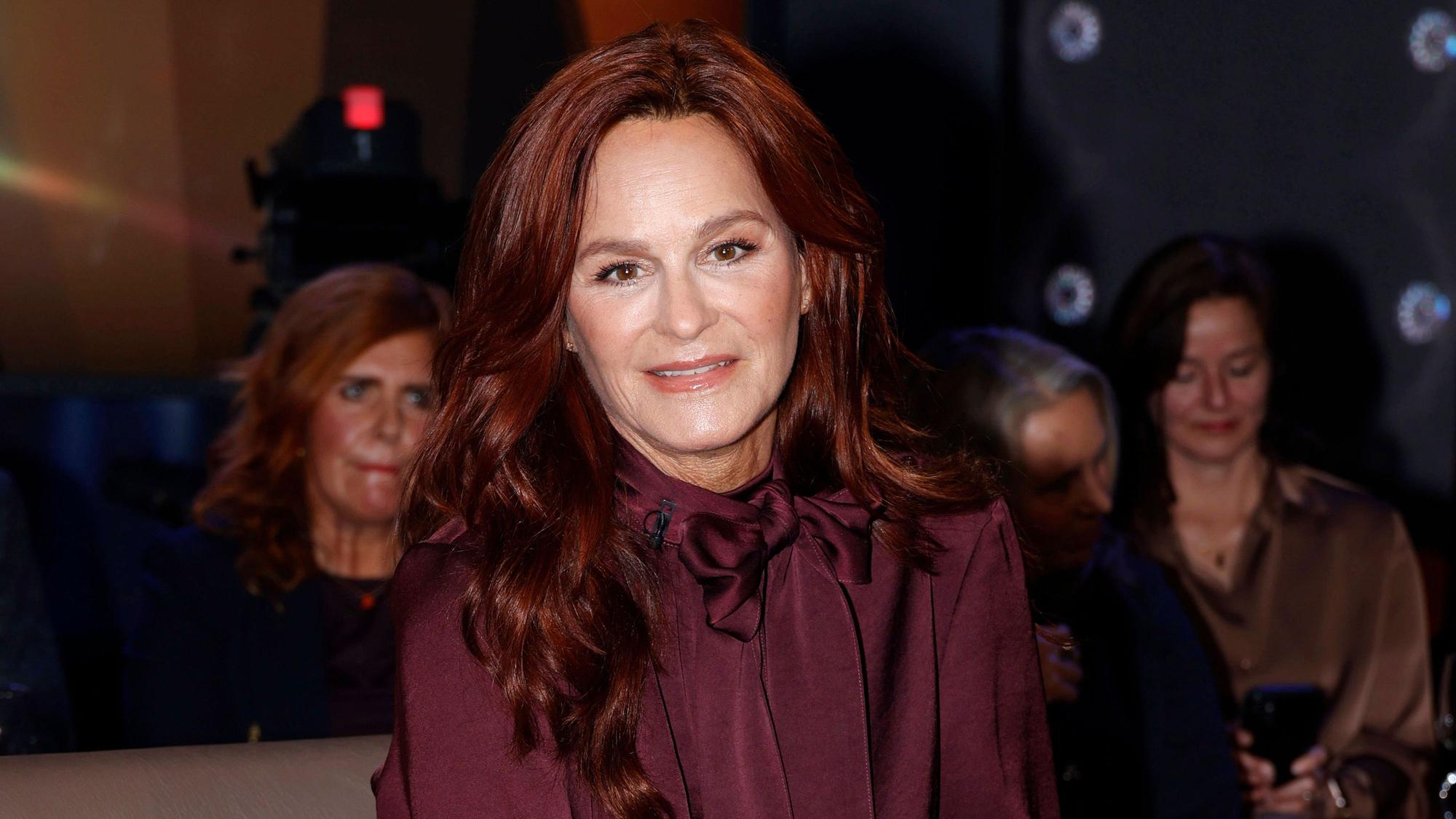 Andrea Berg mit roten Haaren und dunklem Oberteil.