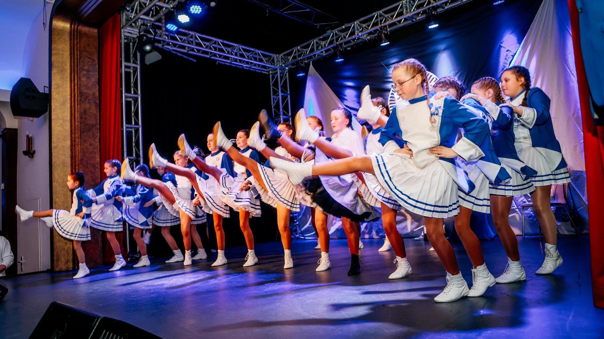Eine Kindertanzgruppe tanzt auf einer Bühne.