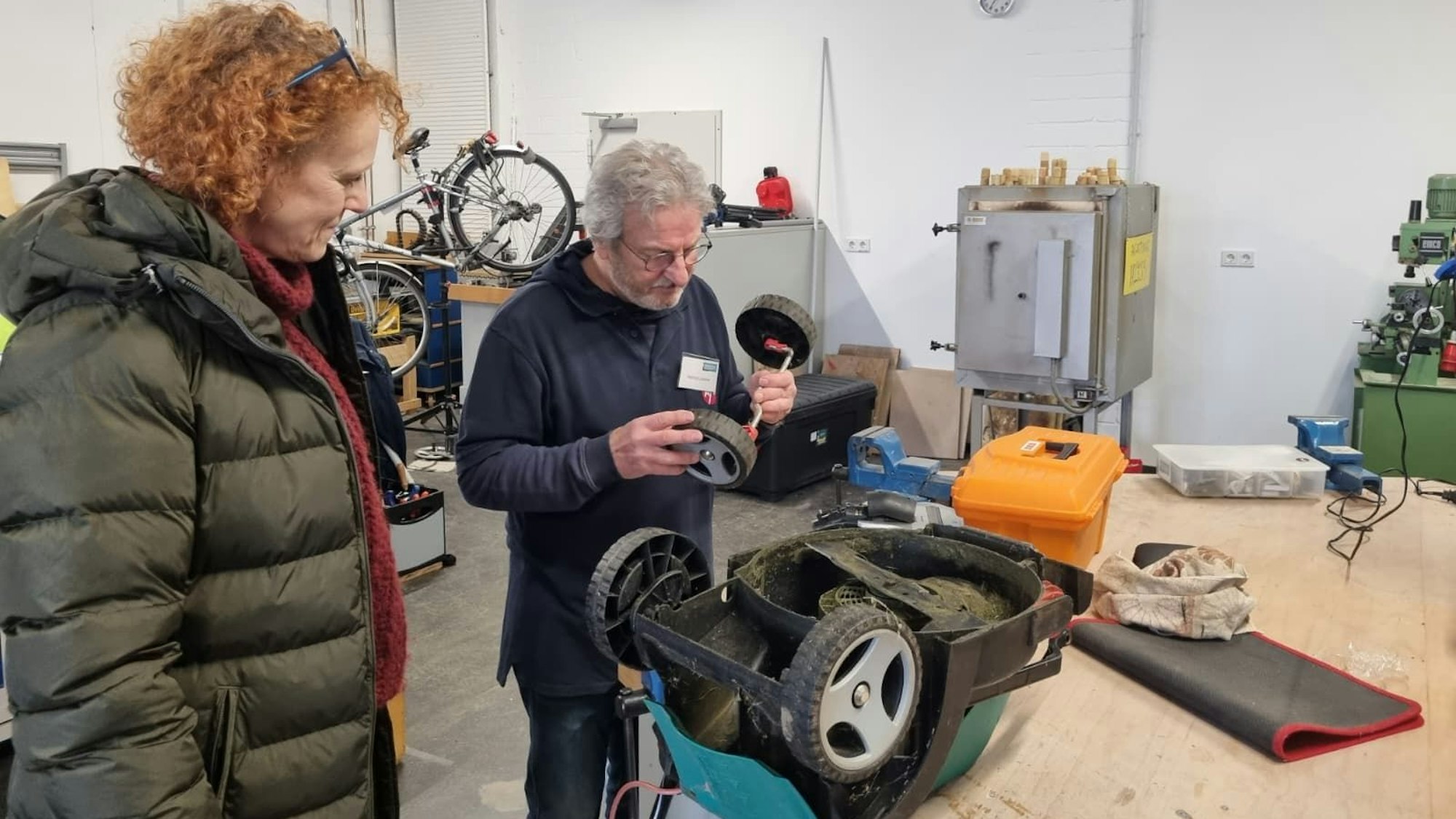 Ein Mann repariert einen Rasenmäher.