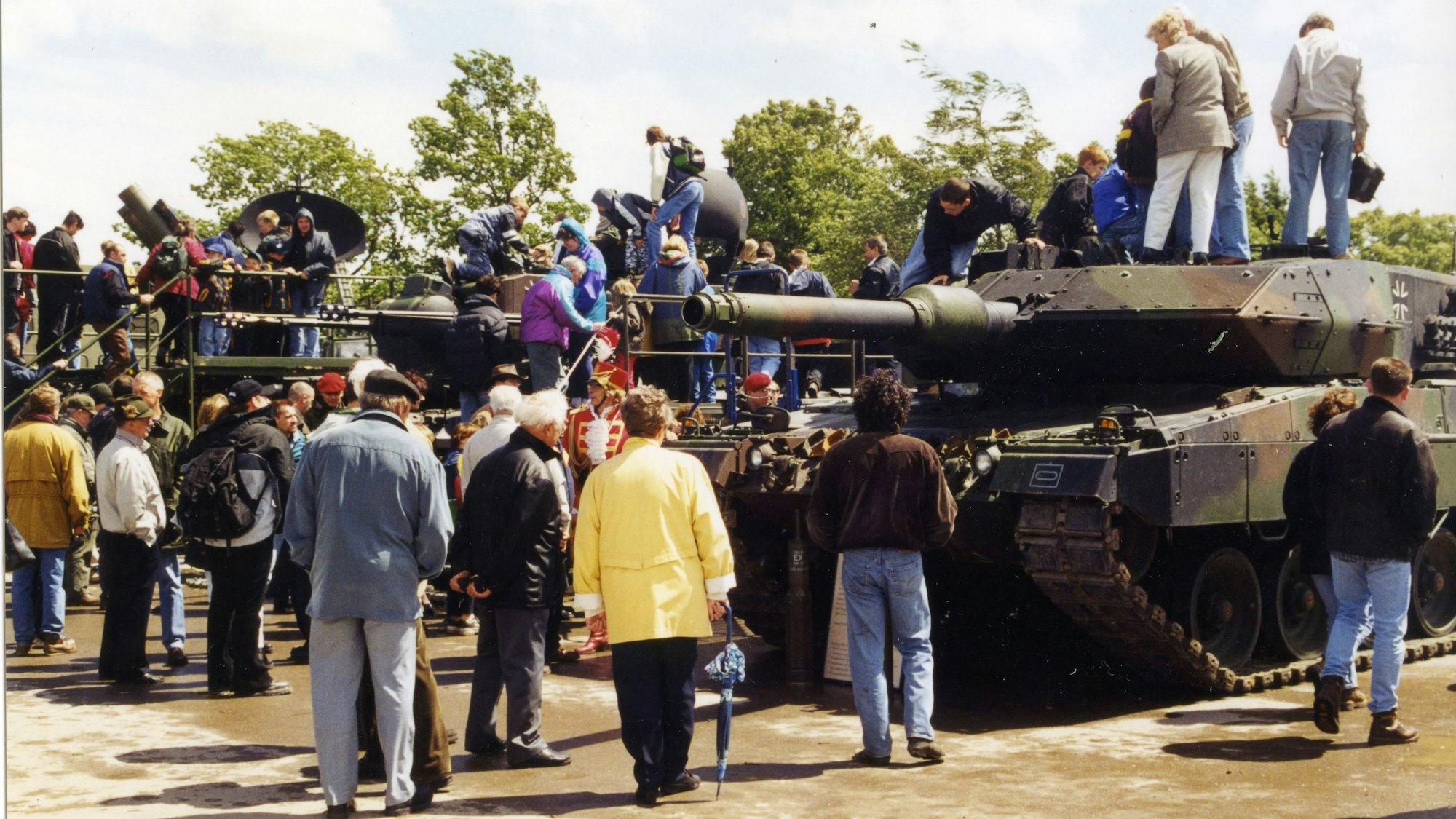 Viele Leute stehen um Panzer herum, einige sind sogar draufgeklettert.