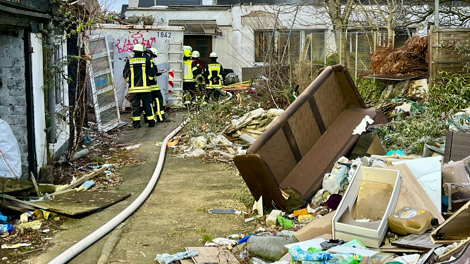Feuerwehrleute in einem Hof an der Peschstraße in Wiesdorf