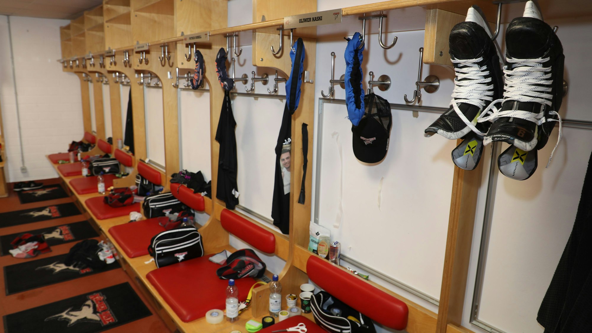Schuhe und Ausrüstung hängen und liegen an den Plätzen der KEC-Spieler in der Kabine.