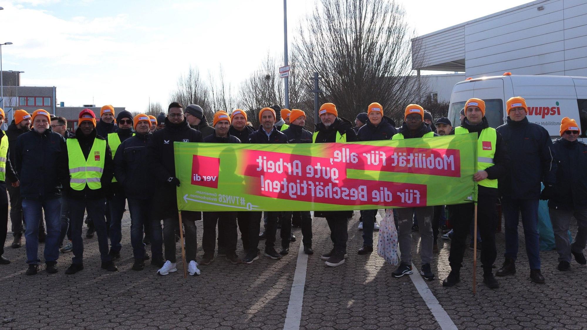 Gruppe von Menschen hält einen Banner.