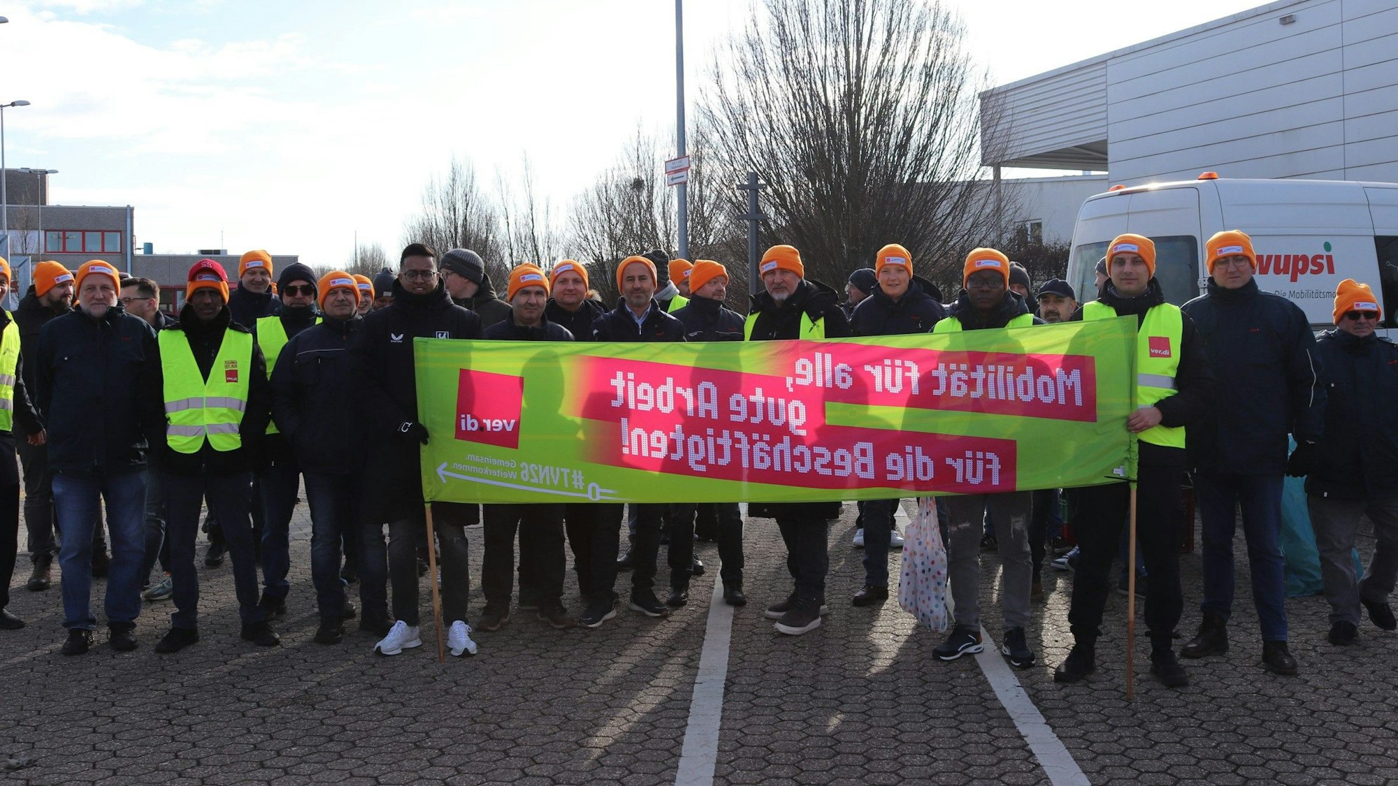 Gruppe von Menschen hält einen Banner.