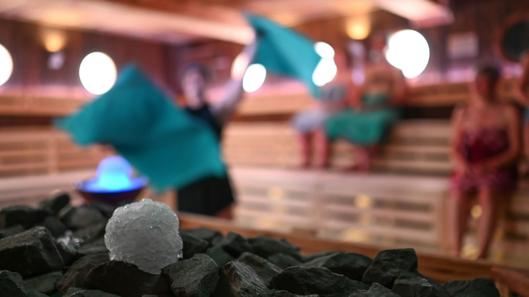 Schneebälle aus Crushed Ice liegen in einer Sauna neben einem Sauna-Ofen für einen Event-Aufguss bereit.