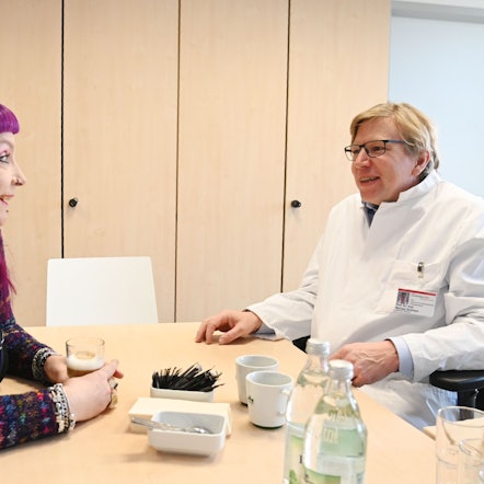 Marike Kruisselbrink und der onkologische Chirurg Professor Dr. Michael Ströhlein sitzen sich gegenüber.