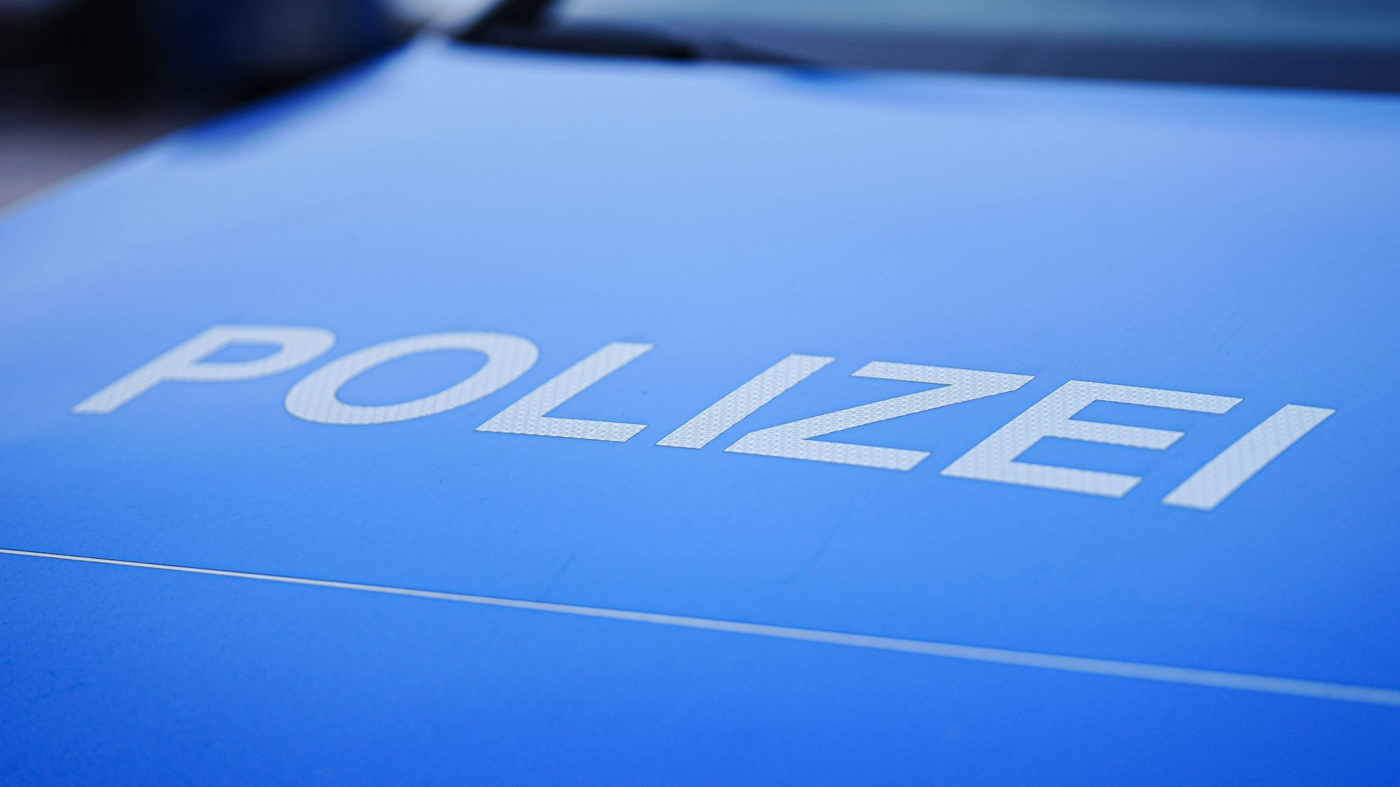 Blaues Polizeiauto mit „POLIZEI“-Schriftzug