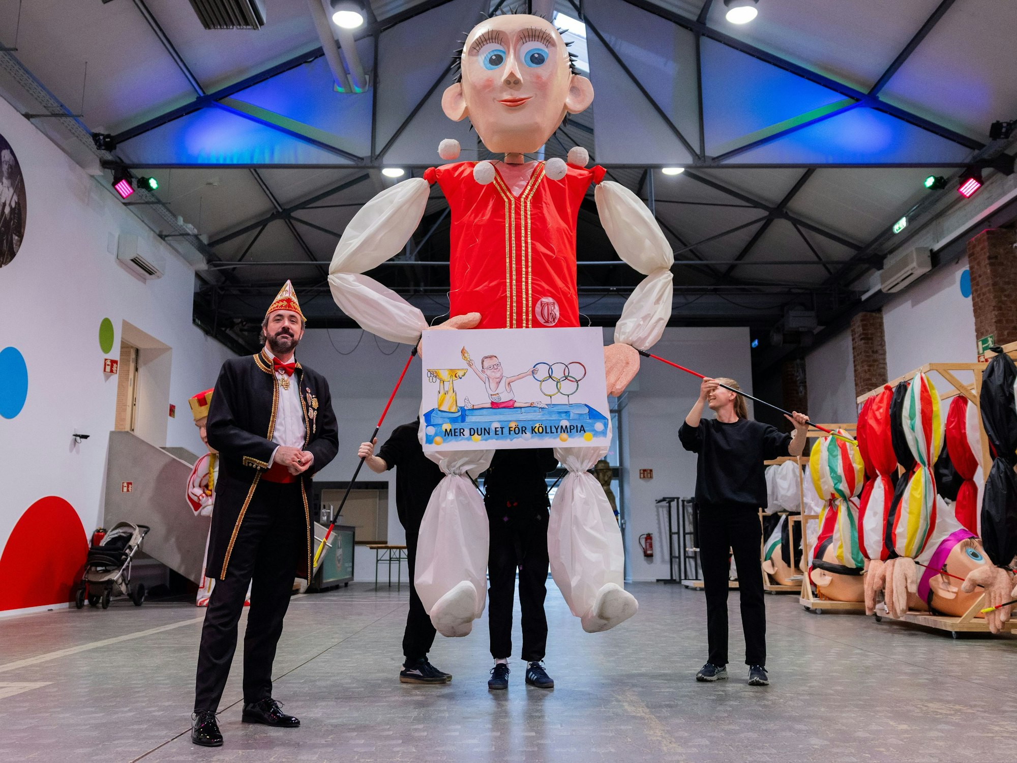 Zugleiter Marc Michelske präsentiert eine Skizze, die einen geplanten Motivwagen zum Thema Olympia (Mer dun et för Köllympia) für den Rosenmontagszug zeigt.