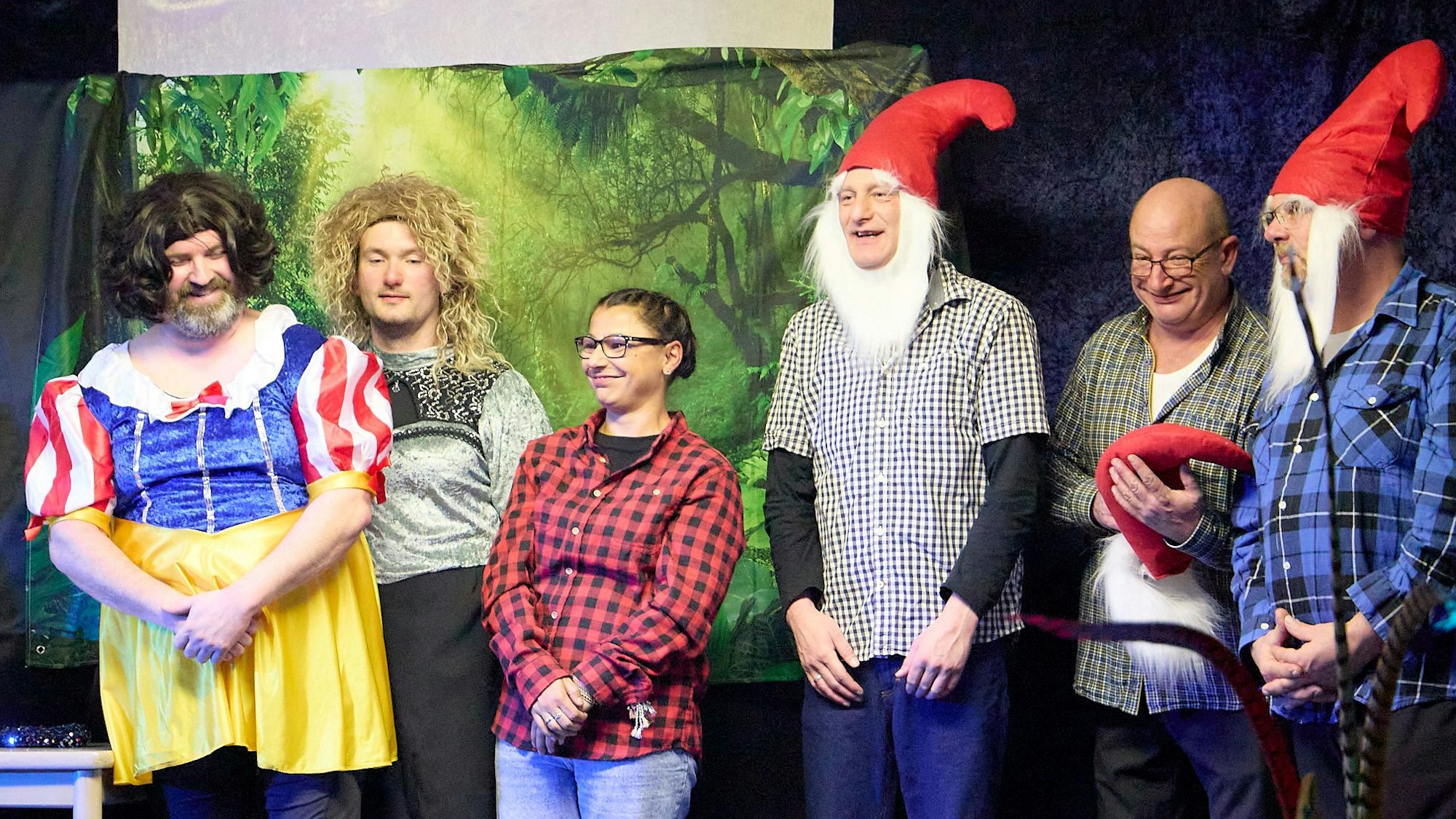 Das Bild zeigt bunt kostümierte Leute, darunter zwei Männer mit roten Zipfelmützen.