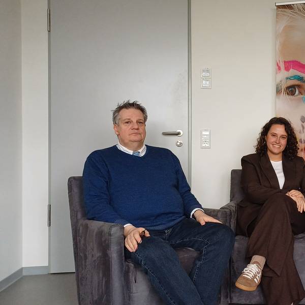 Ein Mann und zwei Frauen sitzen nebeneinander in Sesseln.