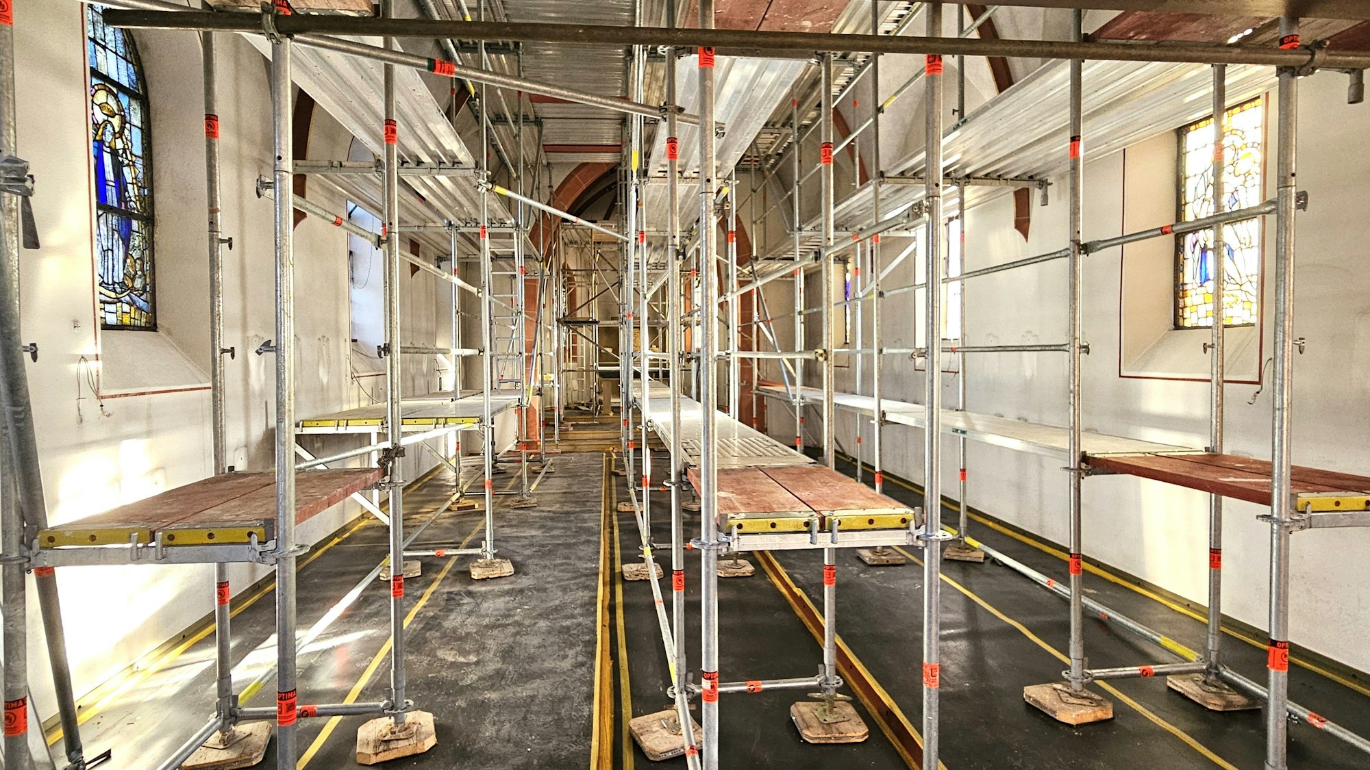 Im Kirchenraum stehen drei Gerüste. Der Boden ist abgedeckt.
