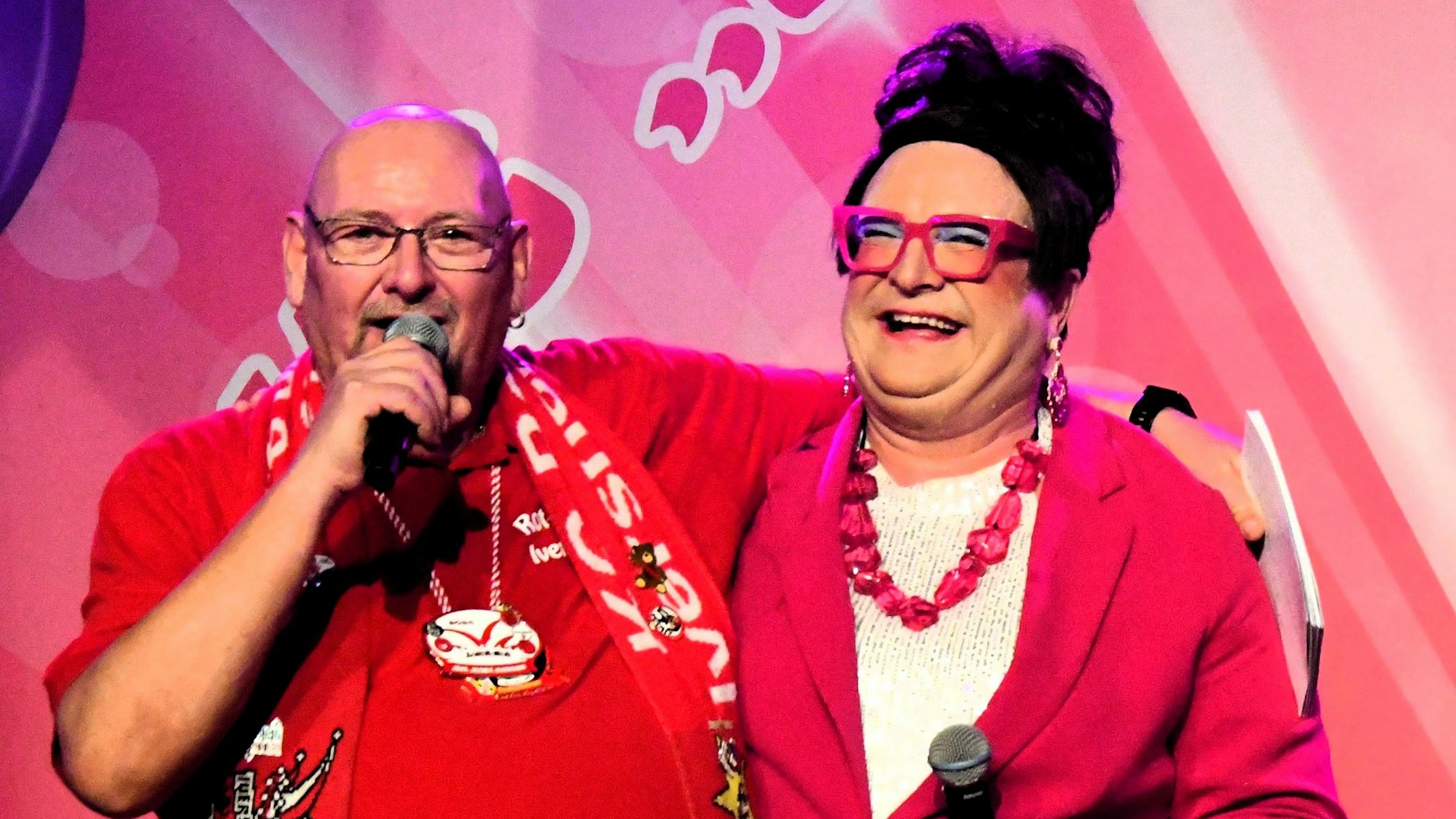 Präsident Erik Gasthaus und Liselotte Lotterlappen stehen bei der Herrensitzung in Iversheim Arm in Arm auf der Bühne.