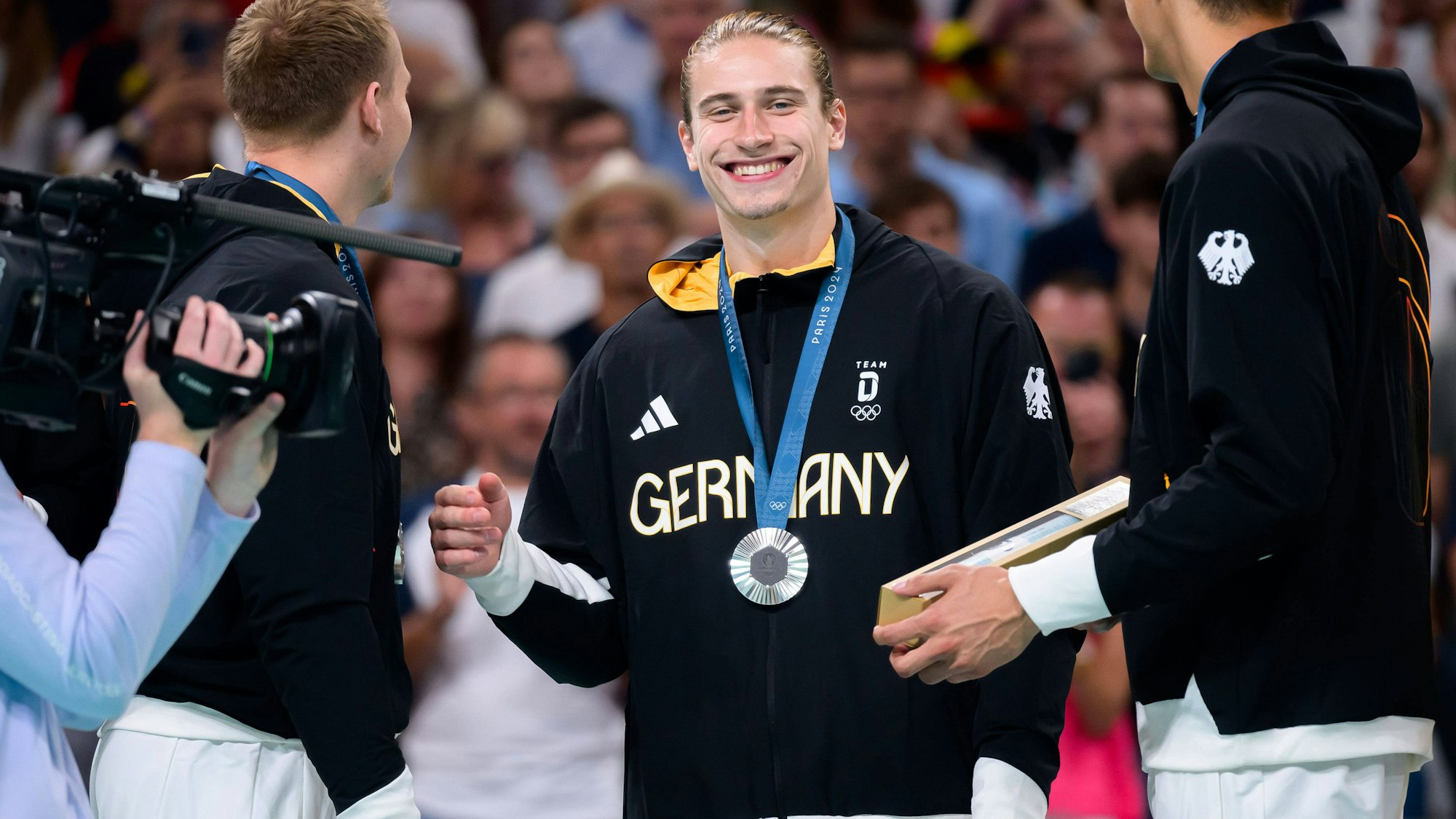 DHB-Spieler Juri Knorr lächelt nach dem verlorenen EM-Finale mit der Silbermedaille um den Hals.