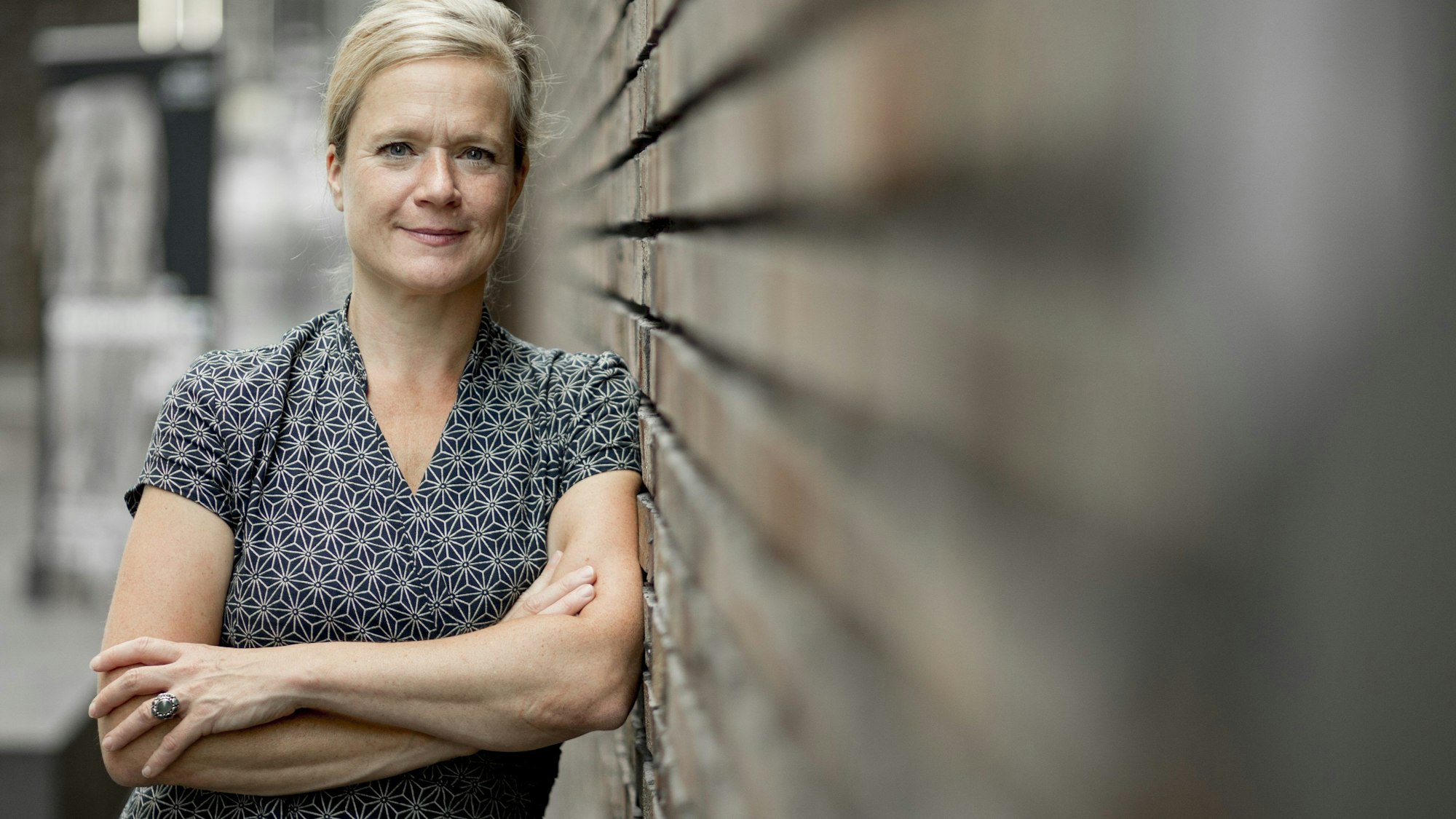 Nanette Jacomijn Snoep steht an eine Mauer gelehnt.