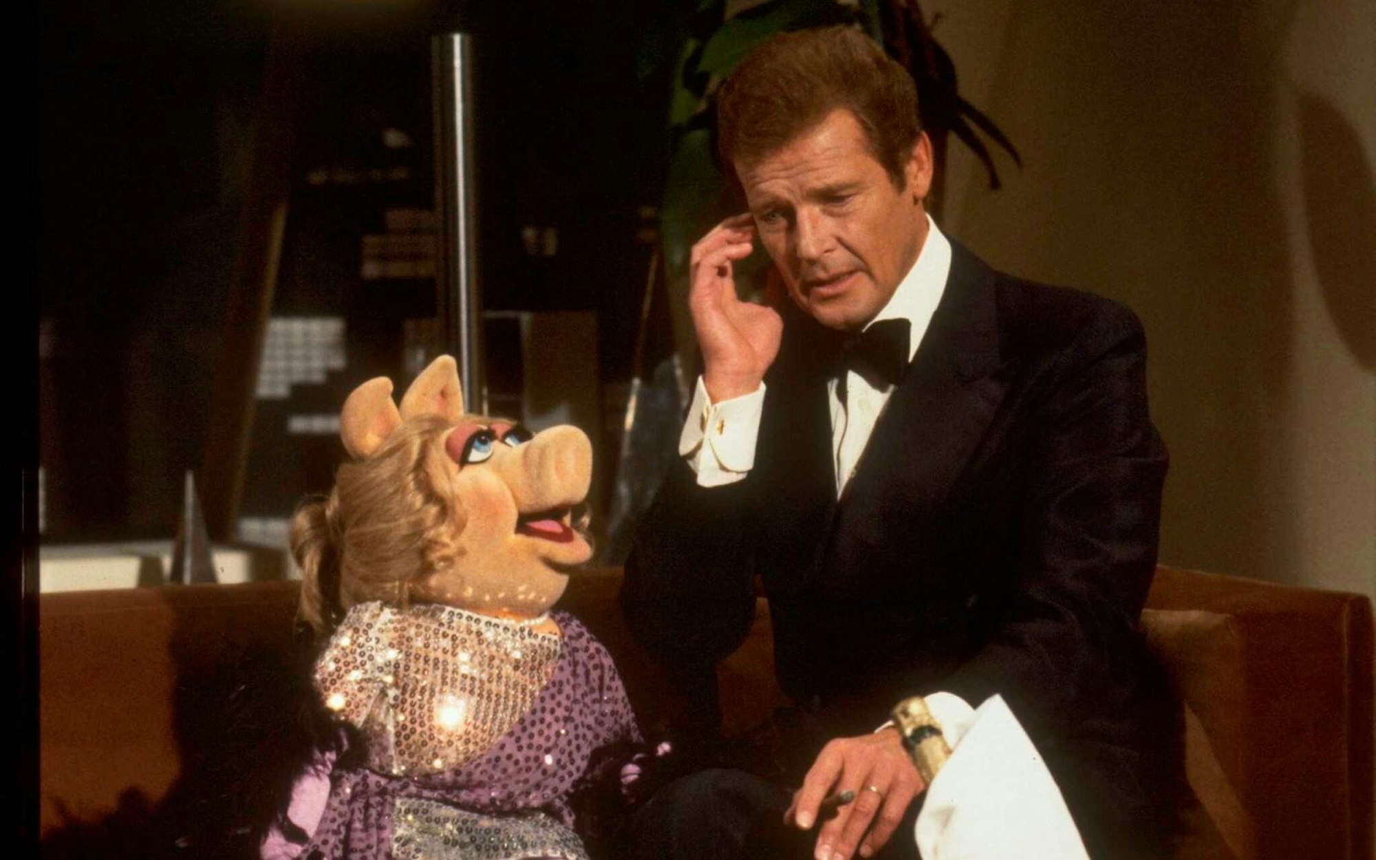 Selbst der berühmteste Geheimagent der Filmgeschichte ließ sich den Besuch bei den Muppets nicht nehmen. In feinem 007-Zwirn nahm Roger Moore als James Bond neben Miss Piggy Platz. (Bild: TV Times via Getty Images)