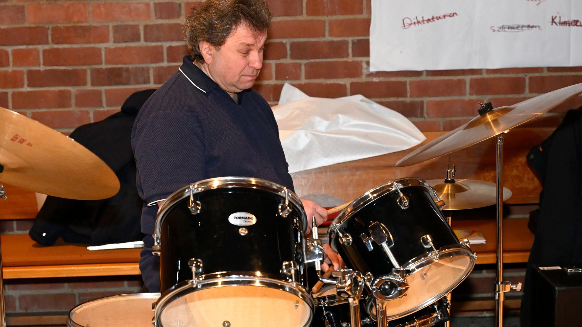 Der Schlagzeuger sitzt vor seinem Instrument.