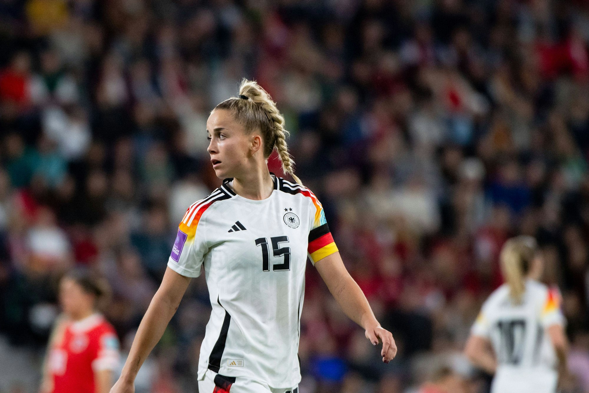 DFB-Kapitänin Giulia Gwinn steht auf dem Fußballfeld und blickt umher.