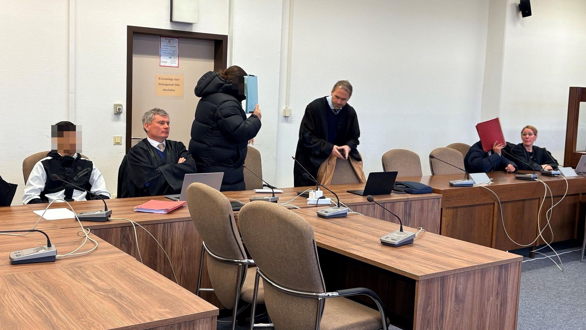 Die drei Angeklagten mit ihren Verteidigern beim Prozessauftakt im Kölner Landgericht