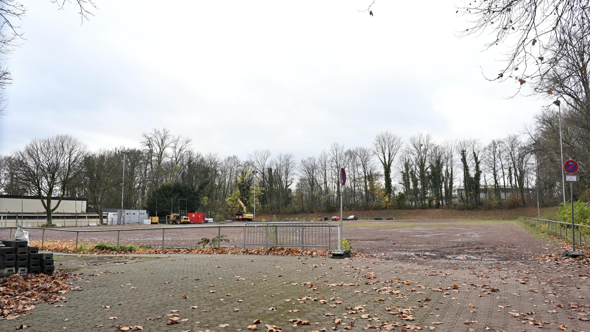 Ein alter sanierungsbedürftiger Ascheplatz. Darauf Herbstlaub.