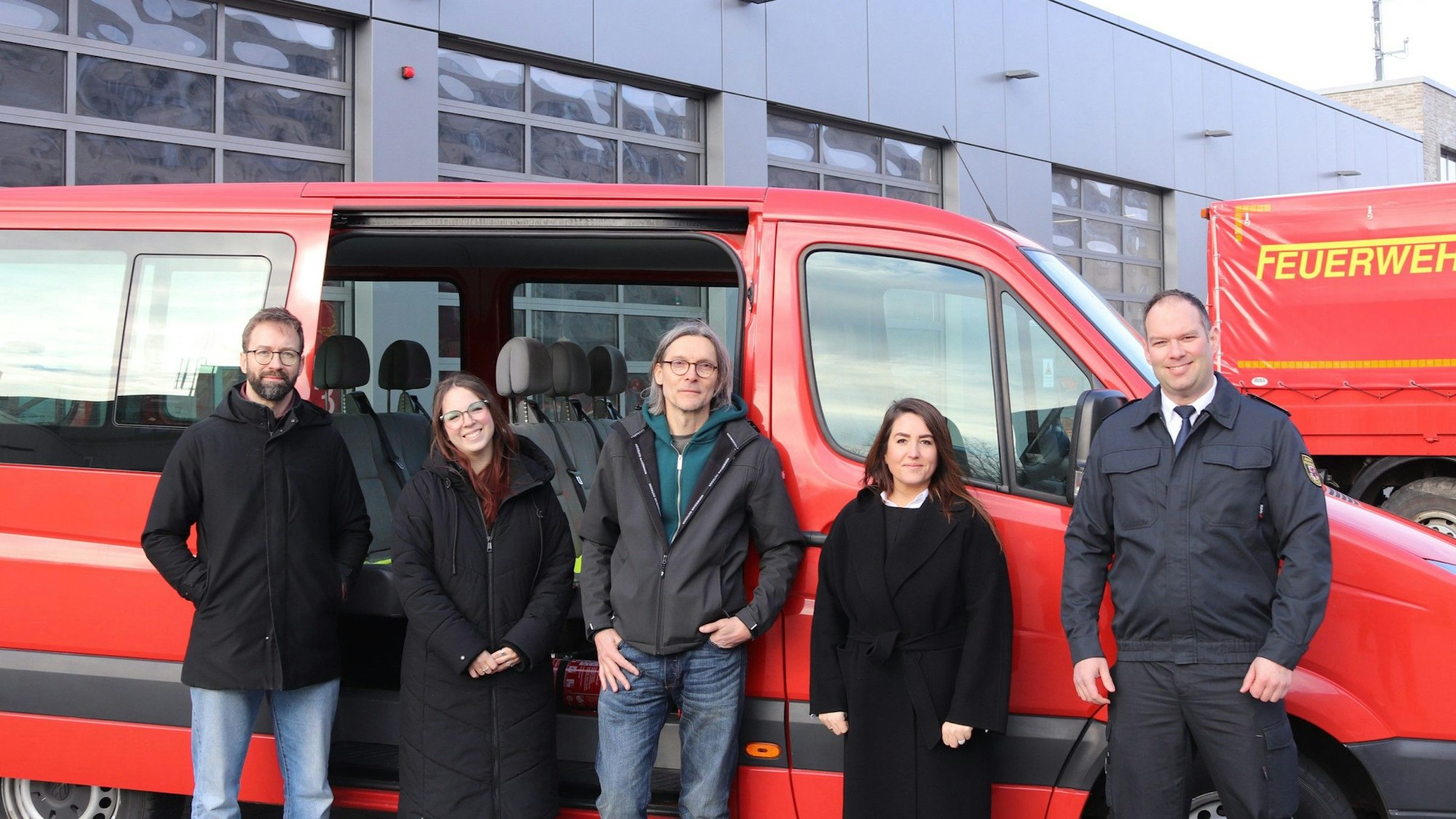 David Nelson (Sachgebietsleiter offene Kinder- und Jugendarbeit), Caroline Wilk (Jugendhaus Lindenhof), Lutz Schröder (Haus der Jugend Opladen), Aylin Dogan (Fachbereichsleiterin Kinder und Jugend) und Thomas Kresse (Leiter der Feuerwehr Leverkusen) vor dem einstigen Feuerwehr-Einsatzwagen.