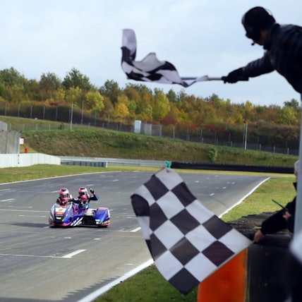 Zu sehen ist die Zieleinfahrt eines Seitenwagen-Gespannes.