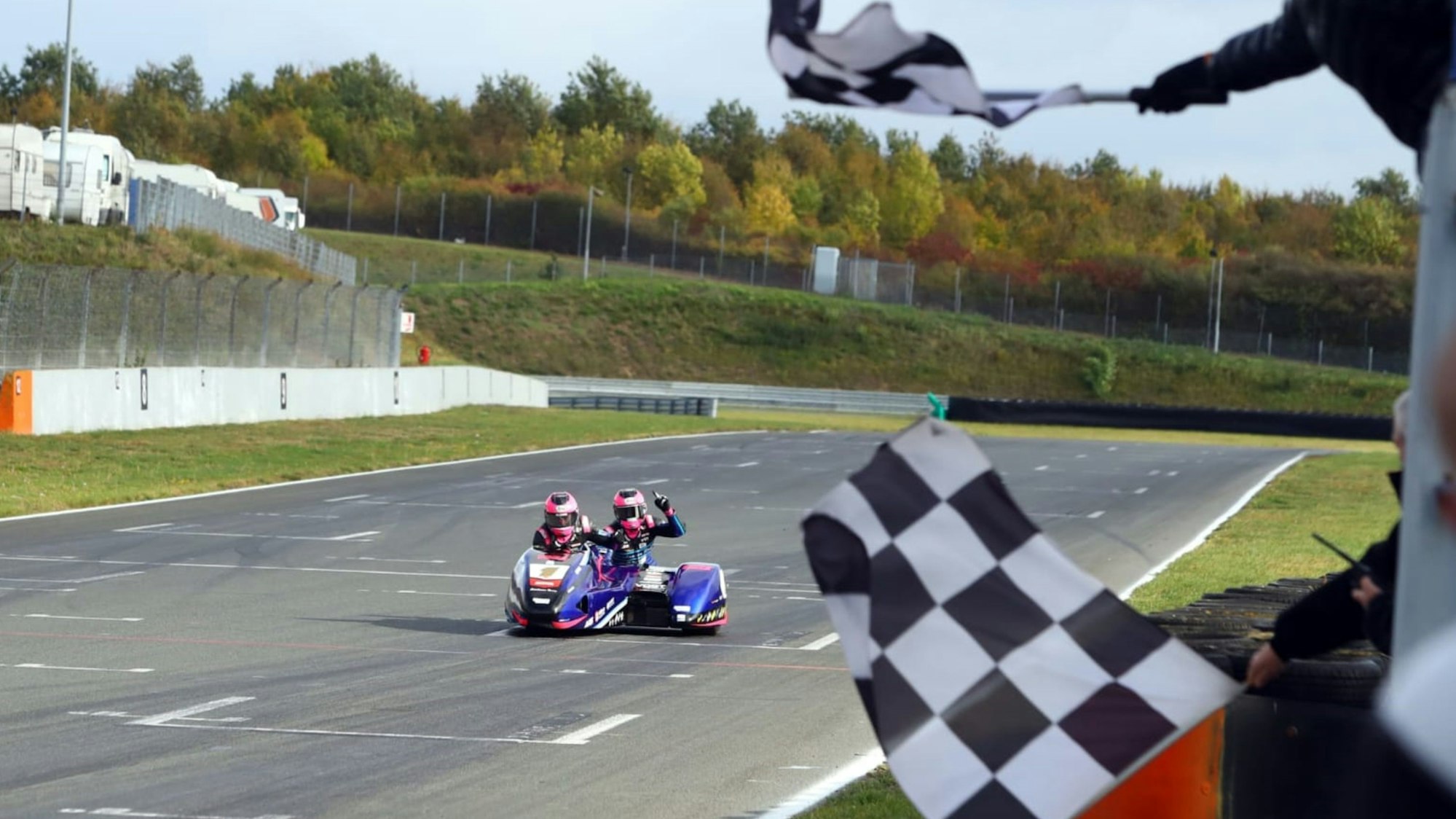 Zu sehen ist die Zieleinfahrt eines Seitenwagen-Gespannes.