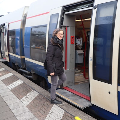 Das Foto zeigt eine Frau, die in eine Regionalbahn einsteigt.