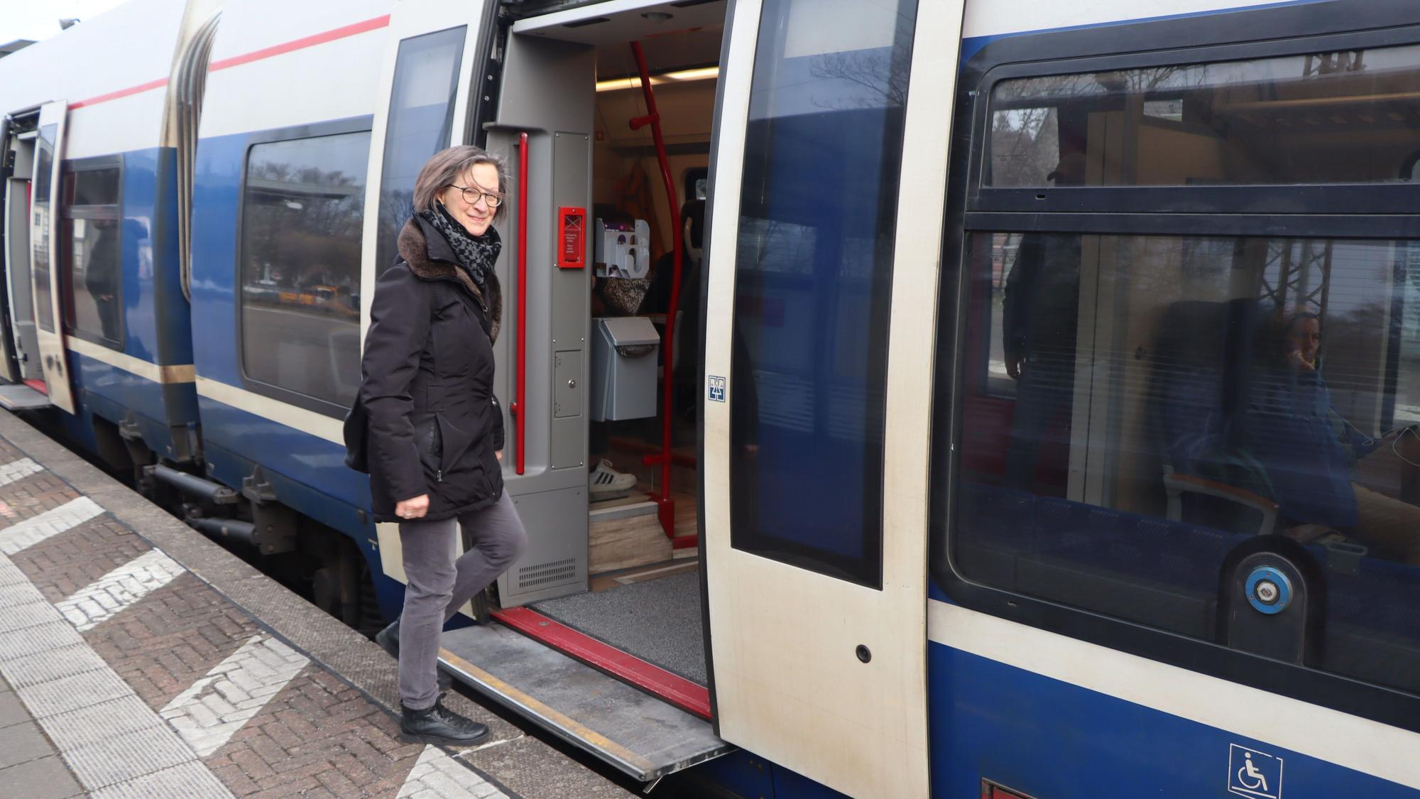 Das Foto zeigt eine Frau, die in eine Regionalbahn einsteigt.
