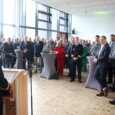 Flottillenadmiral Sabine Reppin ist von hinten am Rednerpult zu sehen. Sie blickt auf die 130 Gäste des Neujahresempfangs.