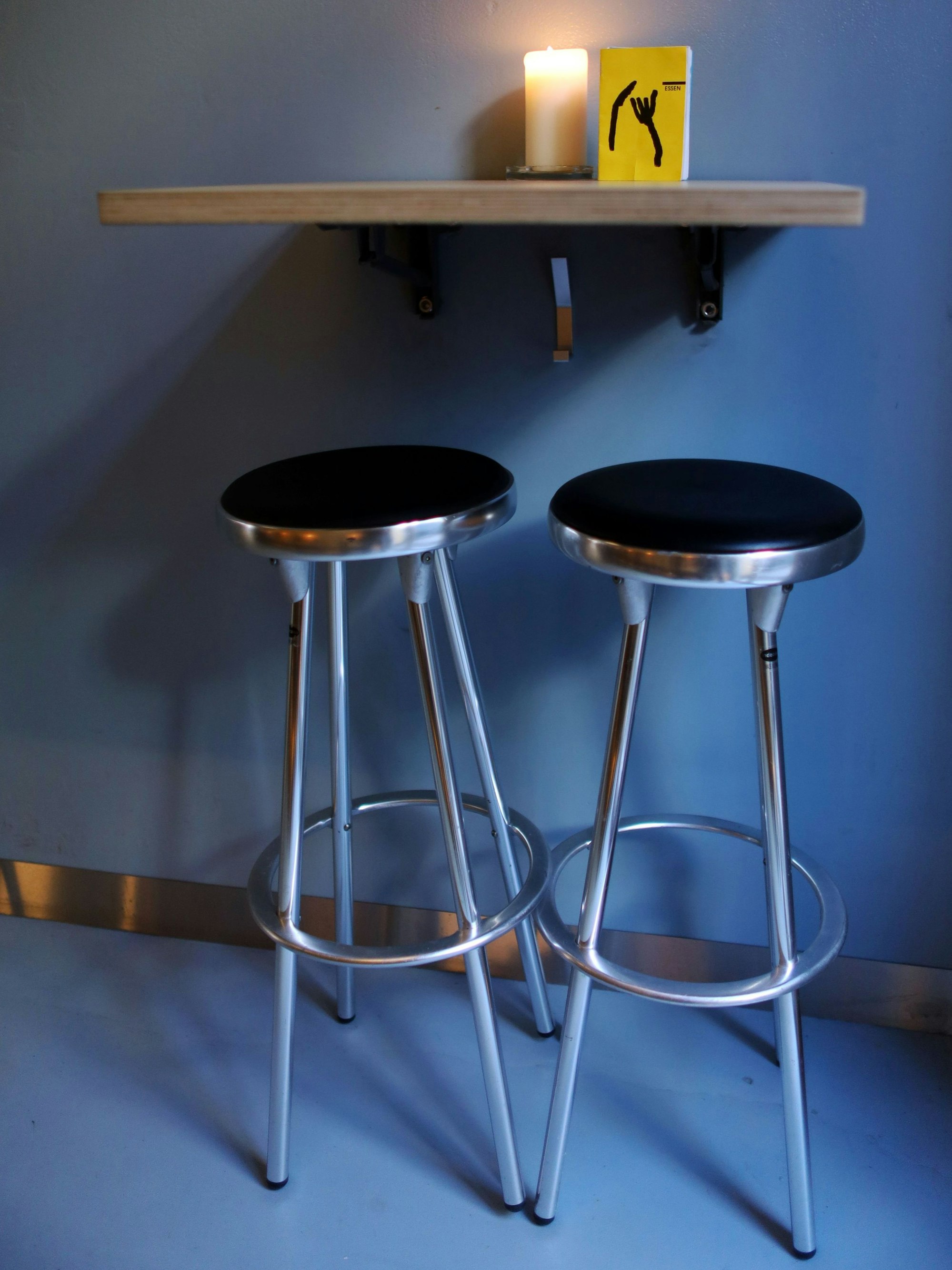 Zwei Barhocker an einem Mini-Wandtisch