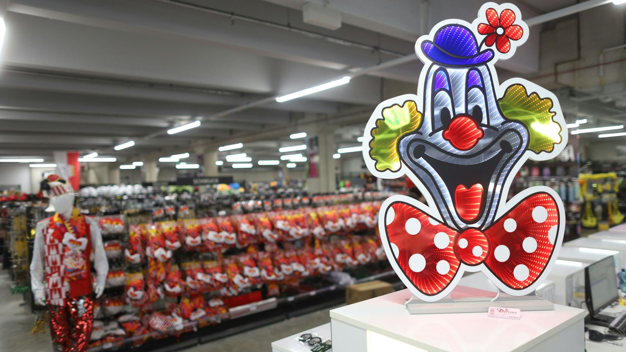 Die Verkaufsfläche von Deiters in Frechen mit einem Logo-Aufsteller und einer in Köln-Farben verkleideten Schaufensterpuppe.