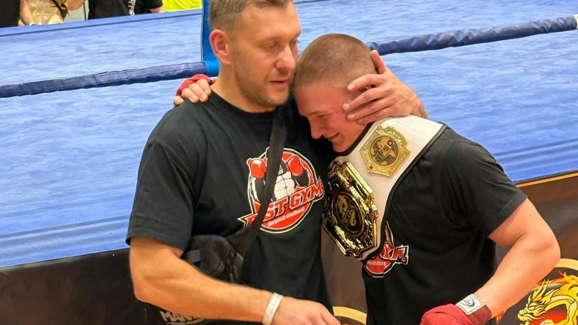 Der Trainer nimmt seinen Schützling in den Arm.