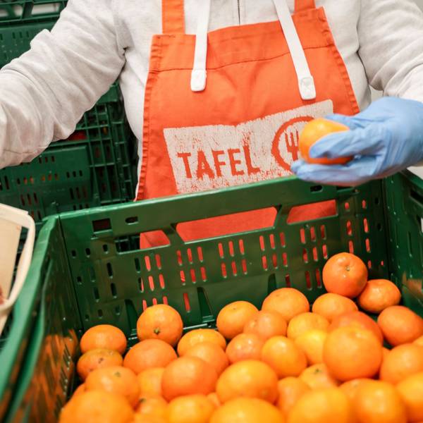 Eine Helferin mit einer Schürze mit Logo der Tafel sortiert bei der Tafel Bremerhaven Obst vor der Ausgabe an die Kunden.