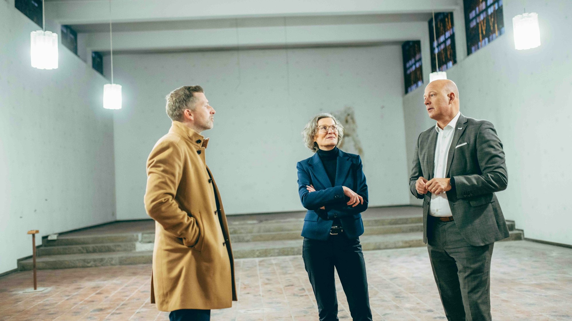 Zu sehen sind Kreisbaudirektor Dr. Andreas Koch, Ministerin Ina Scharrenbach und Landrat Frank Rock (v.l.) bei der gemeinsamen Begehung der ehemaligen Klosterkapelle Mater Salvatoris, die künftig als Veranstaltungsraum genutzt werden soll.