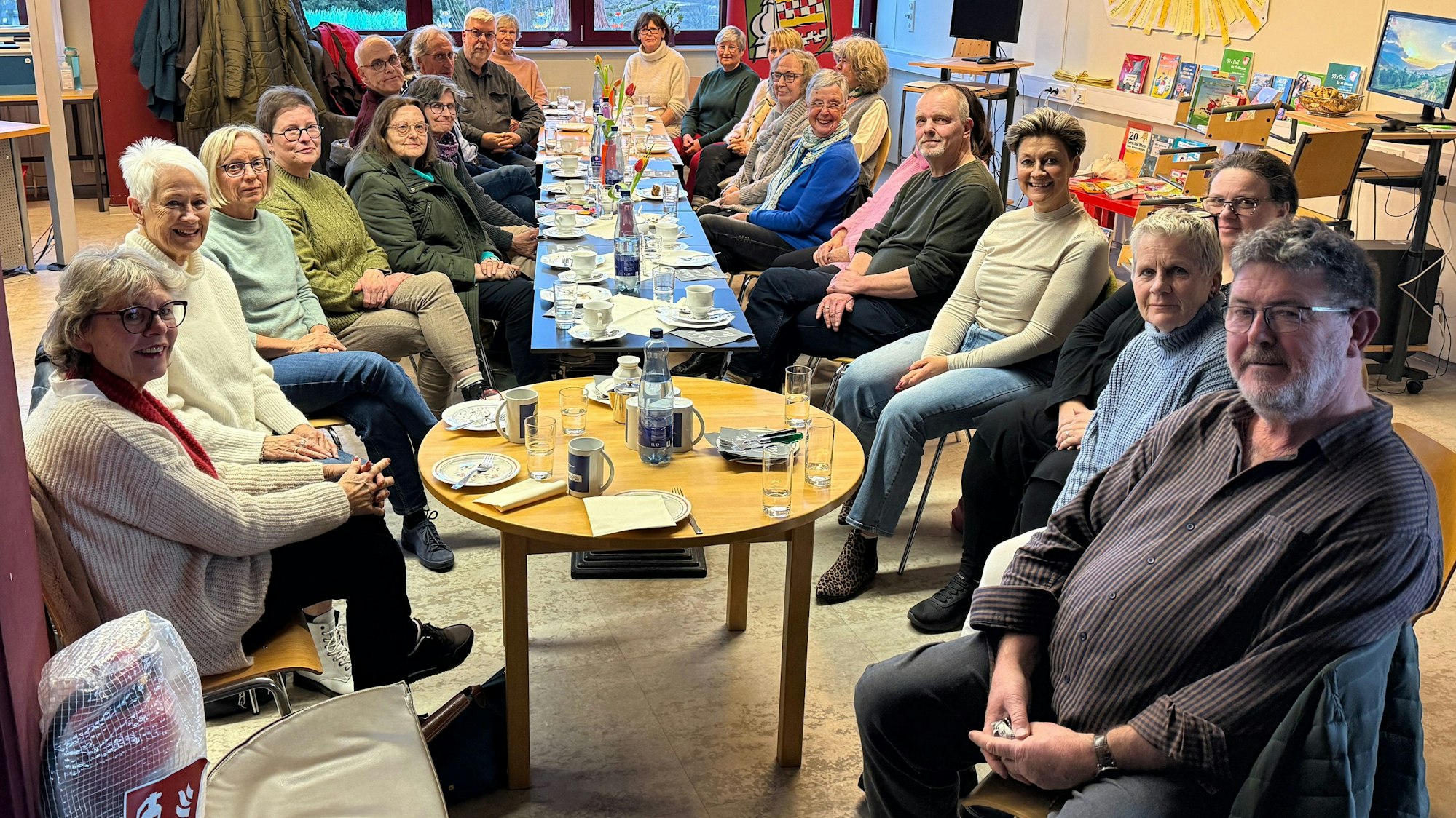 Zu sehen ist eine Versammlung von rund 20 Erwachsenen an einem Tisch