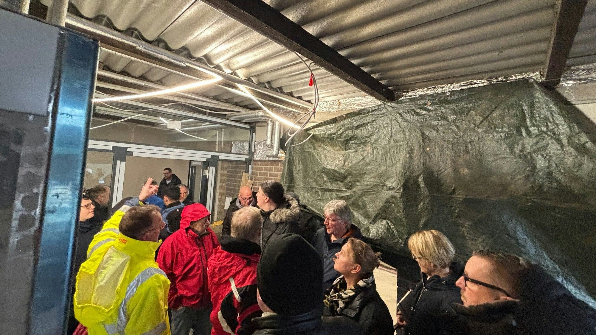 Auf dem Bild ist eine Personengruppe zu sehen, die eine Baustelle besichtigt.