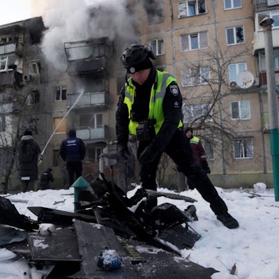 Ein Polizist untersucht in Charkiw Fragmente einer russischen Drohne, die ein Wohnhaus getroffen hat.
