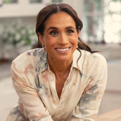 Meghan Markle lächelnd in einem Hemd.