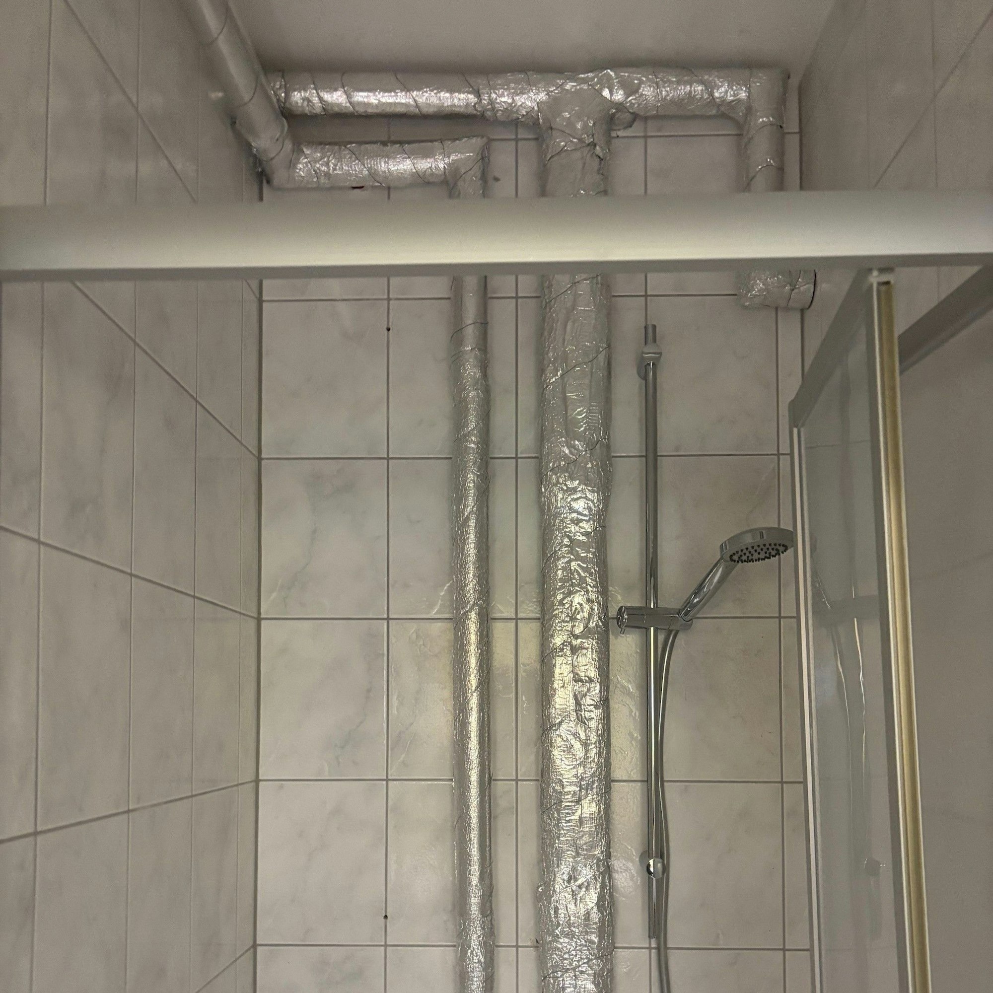 Auf dem Bild sind isolierte Rohre auf Putz zu sehen.