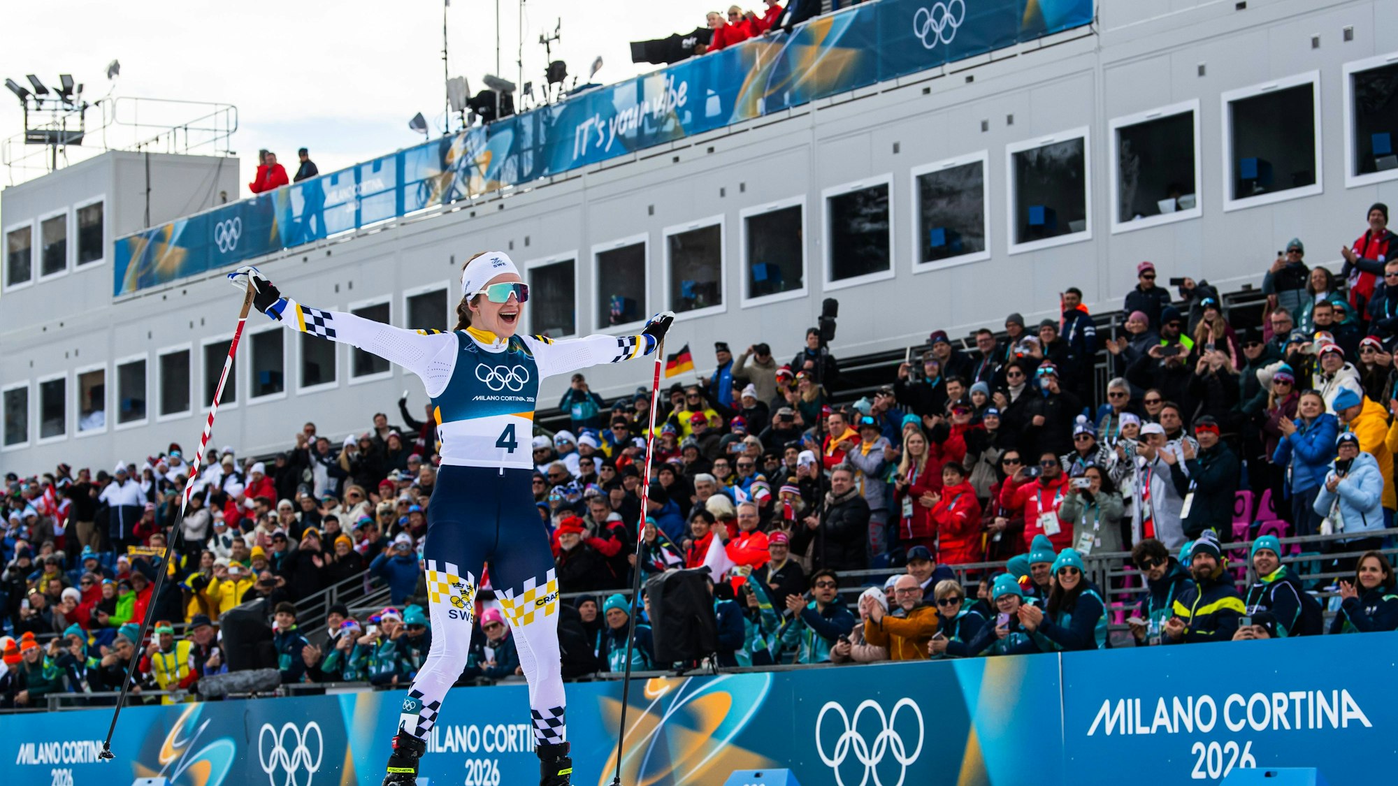 Skilangläuferin Ebba Andersson jubelt vor Zuschauern bei ihrer Zieleinfahrt.