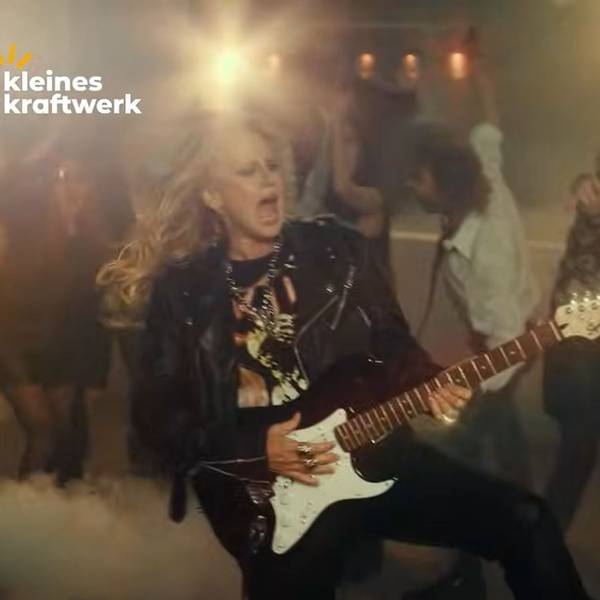 Barbara Schöneberger spielt E-Gitarre im Werbevideo von Kleines Kraftwerk Balkonkraftwerke.