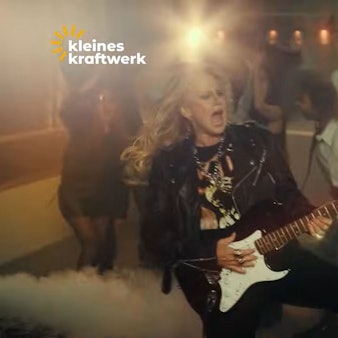 Barbara Schöneberger spielt E-Gitarre im Werbevideo von Kleines Kraftwerk Balkonkraftwerke.