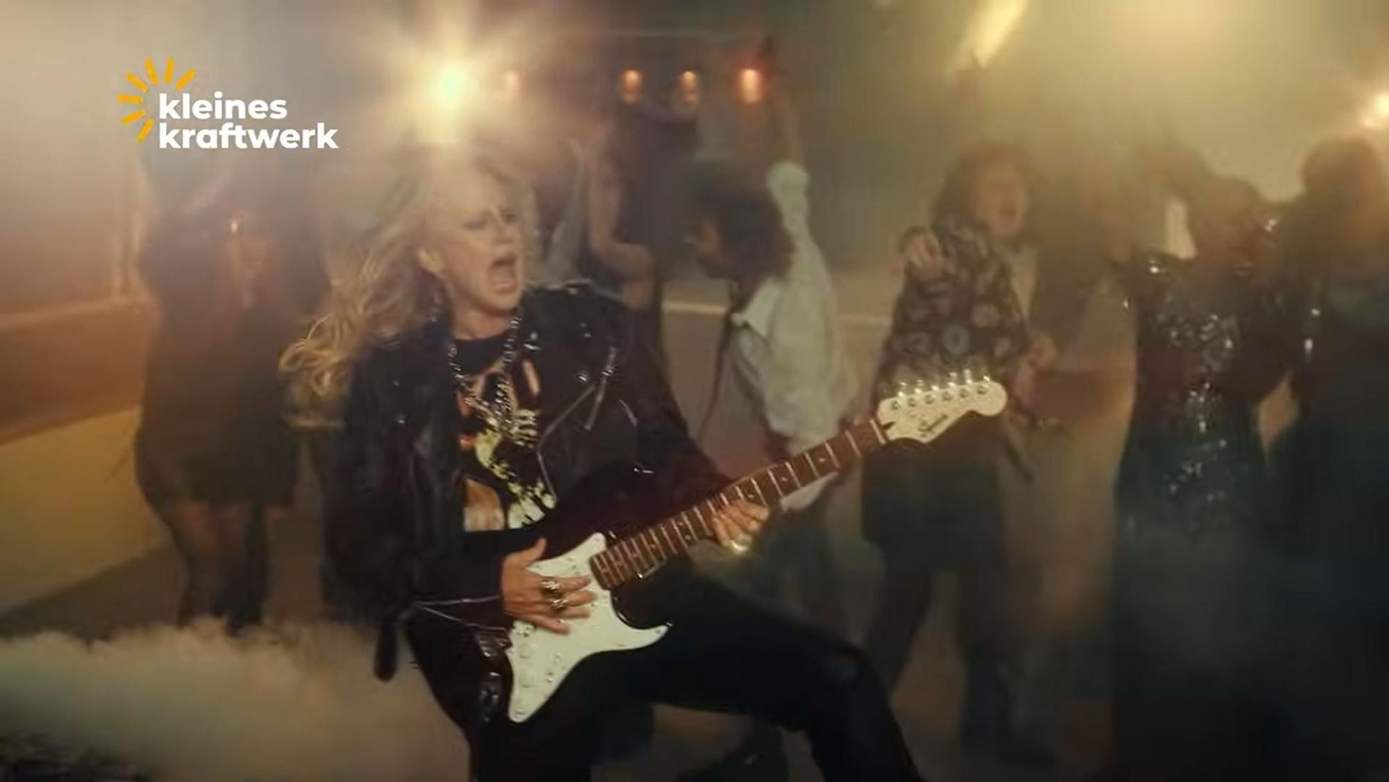 Barbara Schöneberger spielt E-Gitarre im Werbevideo von Kleines Kraftwerk Balkonkraftwerke.
