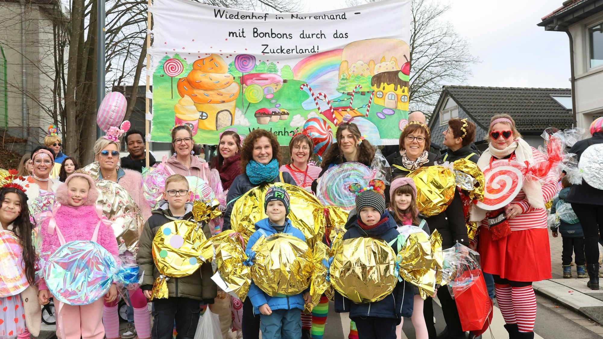 Eine Gruppe ist bei einem Karnevalszug als Bonbons verkleidet.