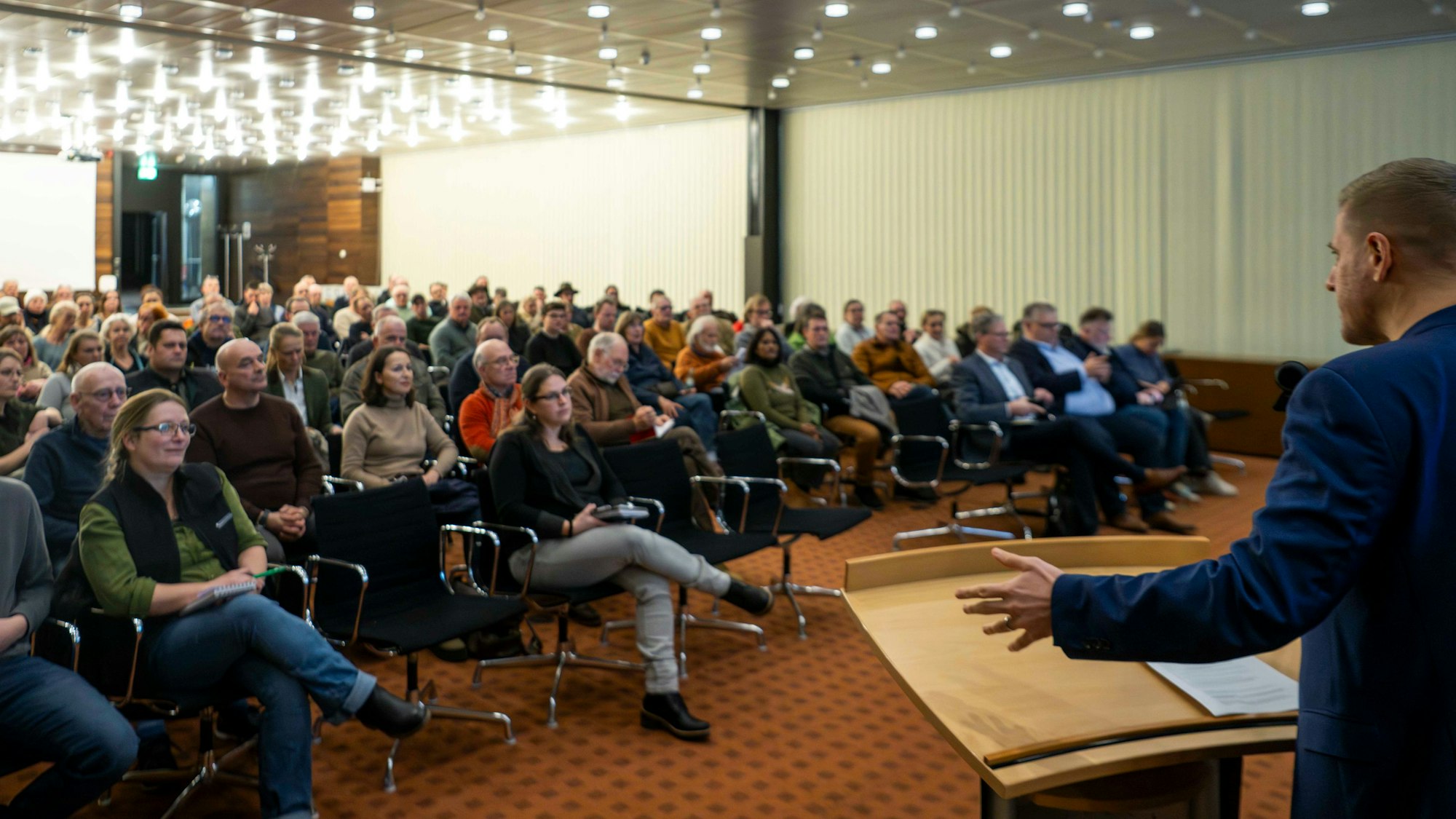 Landrat Markus Ramers spricht vor einer Gruppe Menschen, die im Sitzungssaal des Euskirchener Kreishauses Platz genommen haben.