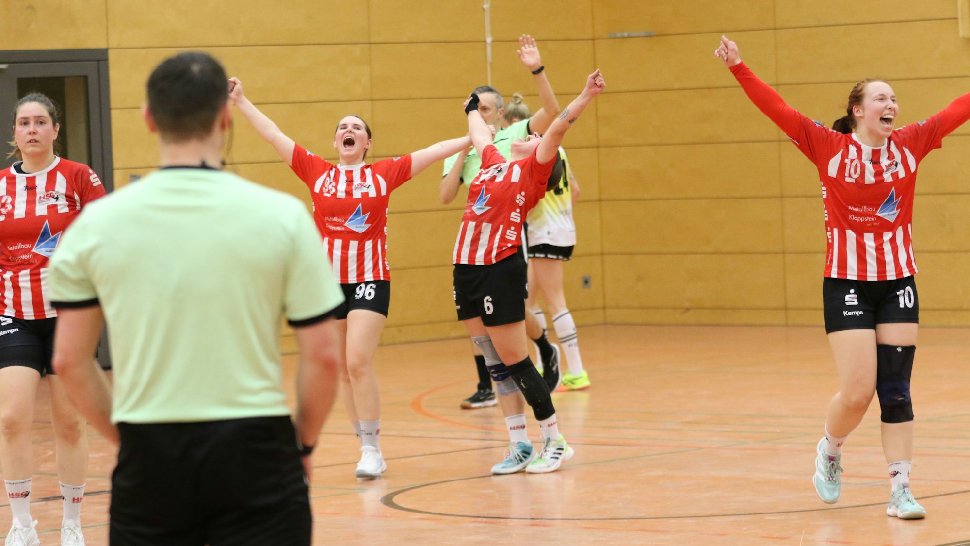 Spielerinnen der HSG Euskirchen jubeln erlöst und recken die Arme in die Höhe.