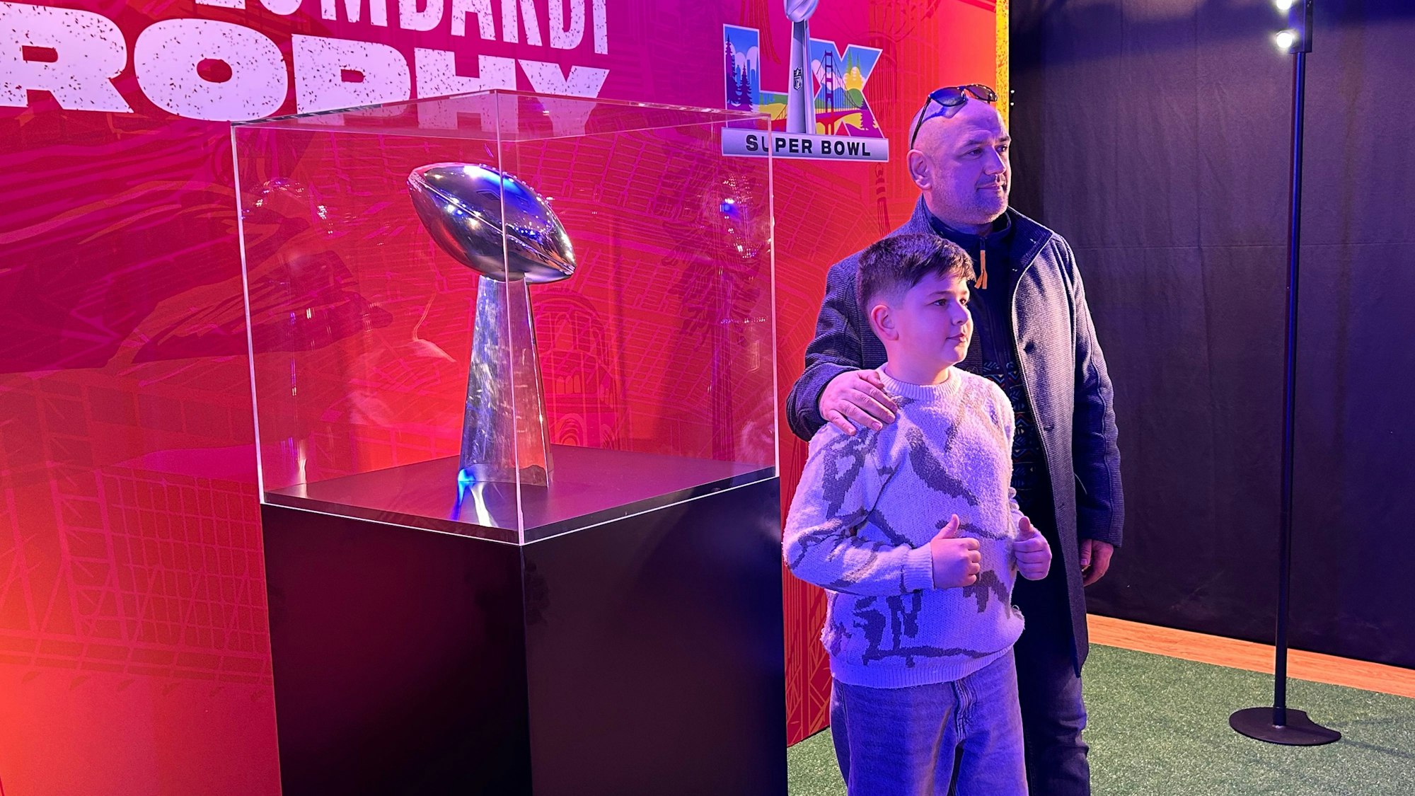 Gäste lassen sich vor der Vince-Lombardi-Trophy fotografieren.