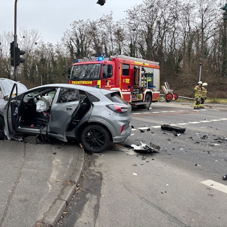 Im Vordergrund ein Fahrzeug mit Unfallspuren. Gas- und Fahrzeugsplitter lagen weit über die Kreuzung verteilt. Im Hintergrund Feuerwehr- und Notarztfahrzeuge.
