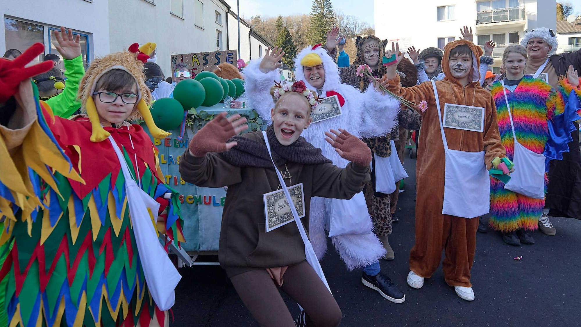 Verkleidete Kinder heben die Hände und machen fröhliche Gesichter.
