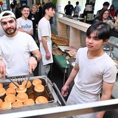 Ein Bäcker backt Berliner.